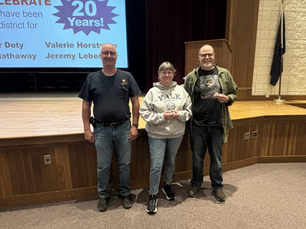 three proud people presenting award.