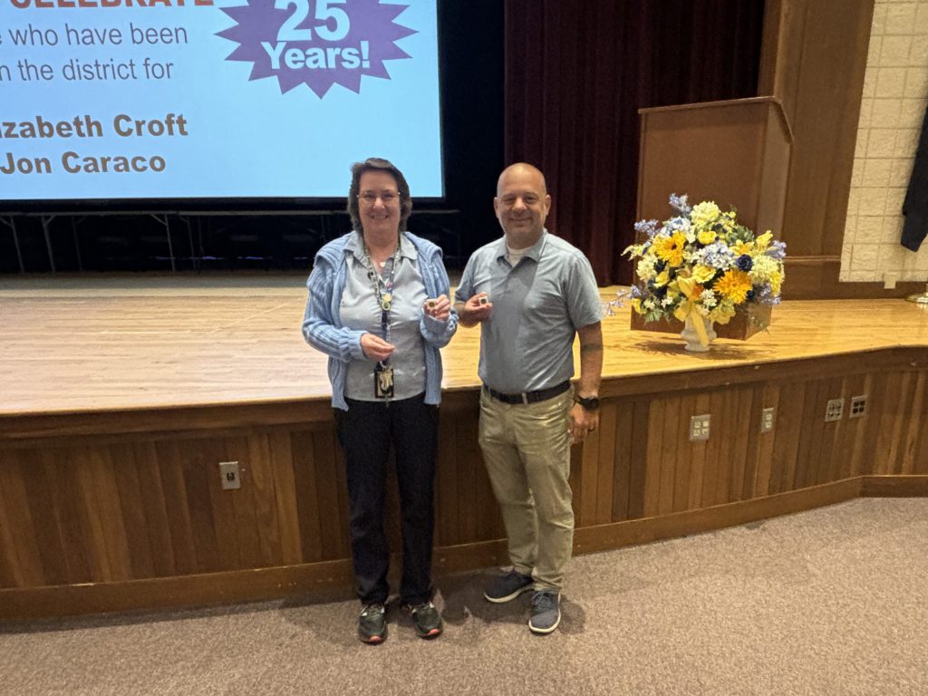 two proud people presenting award.