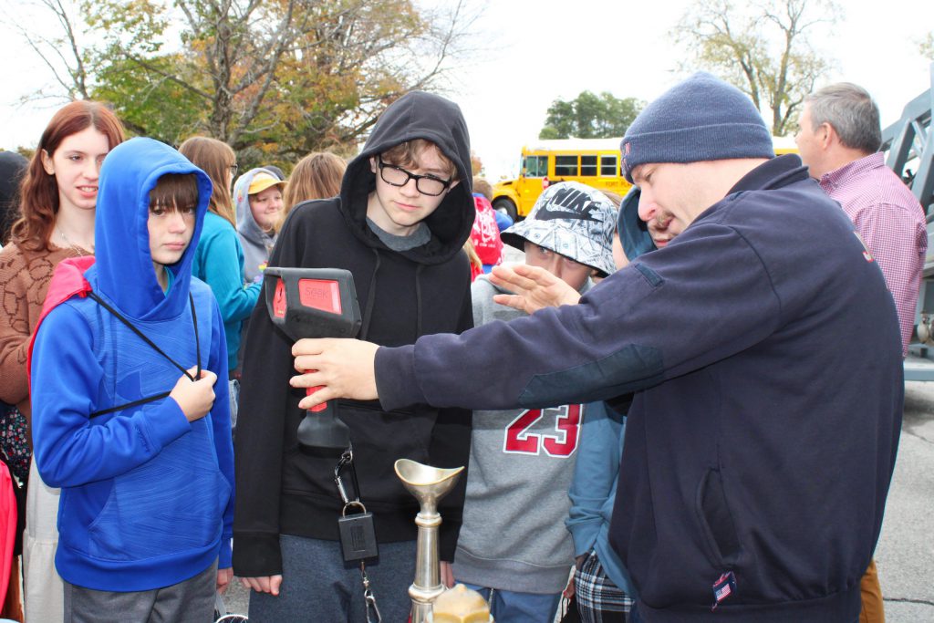 students looking at something with an adult