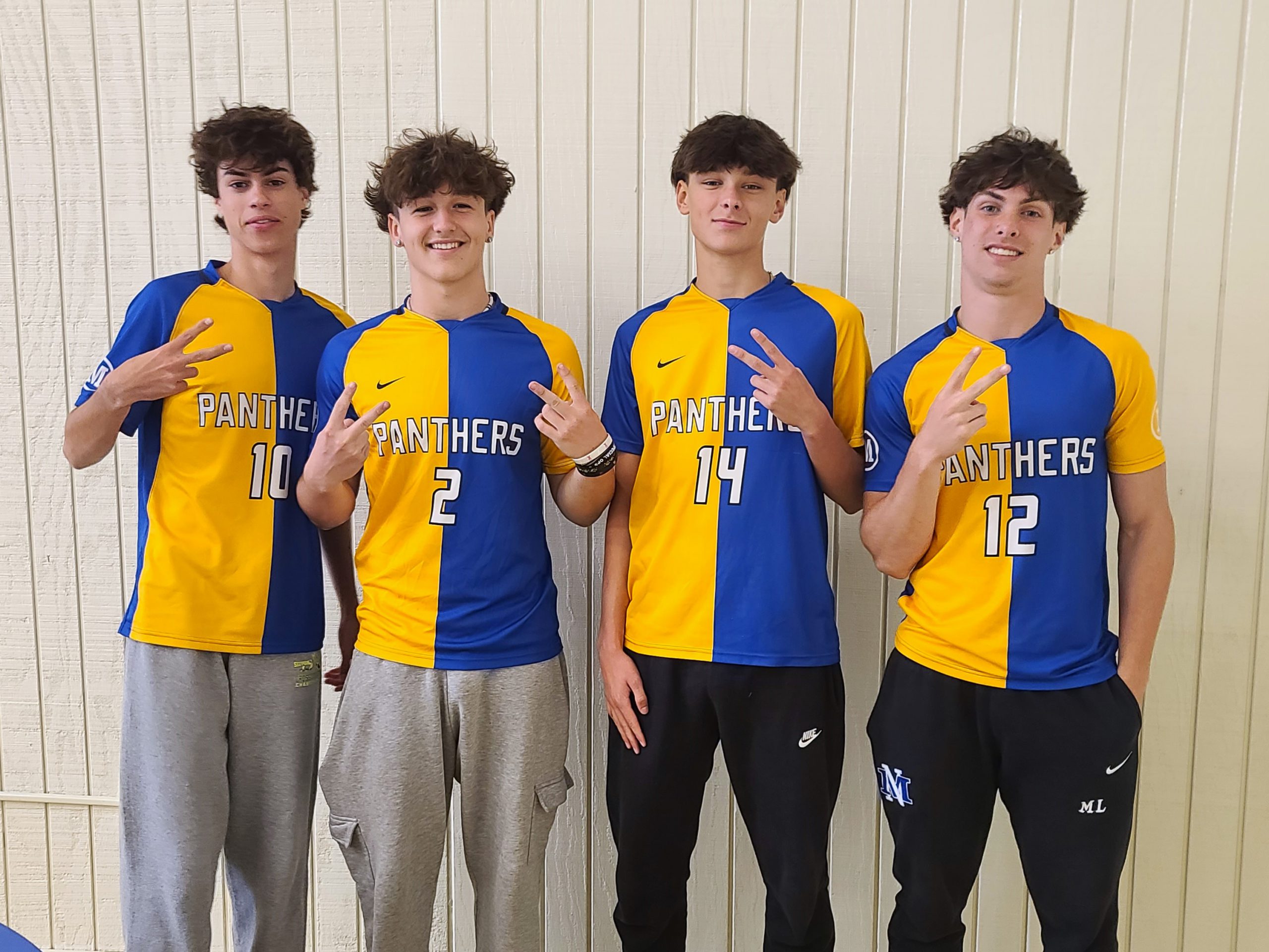 four students in Mayfield uniforms give peace signs