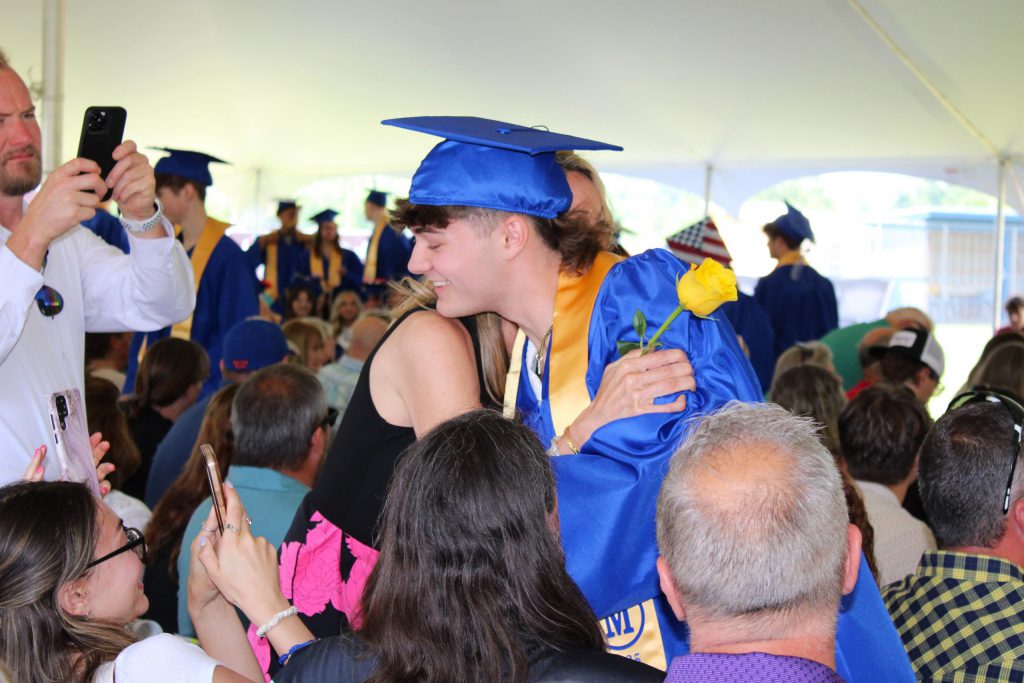 Photo of graduate embraced in hug