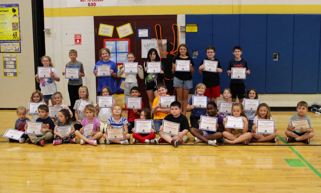 three rows of students posing with certificates