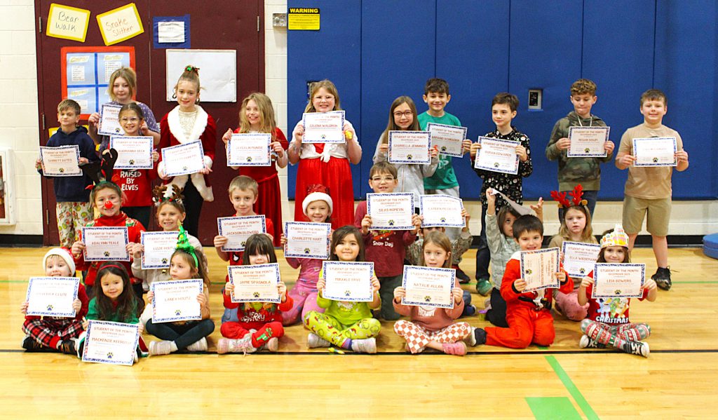 Students stand in three rows holding certificates