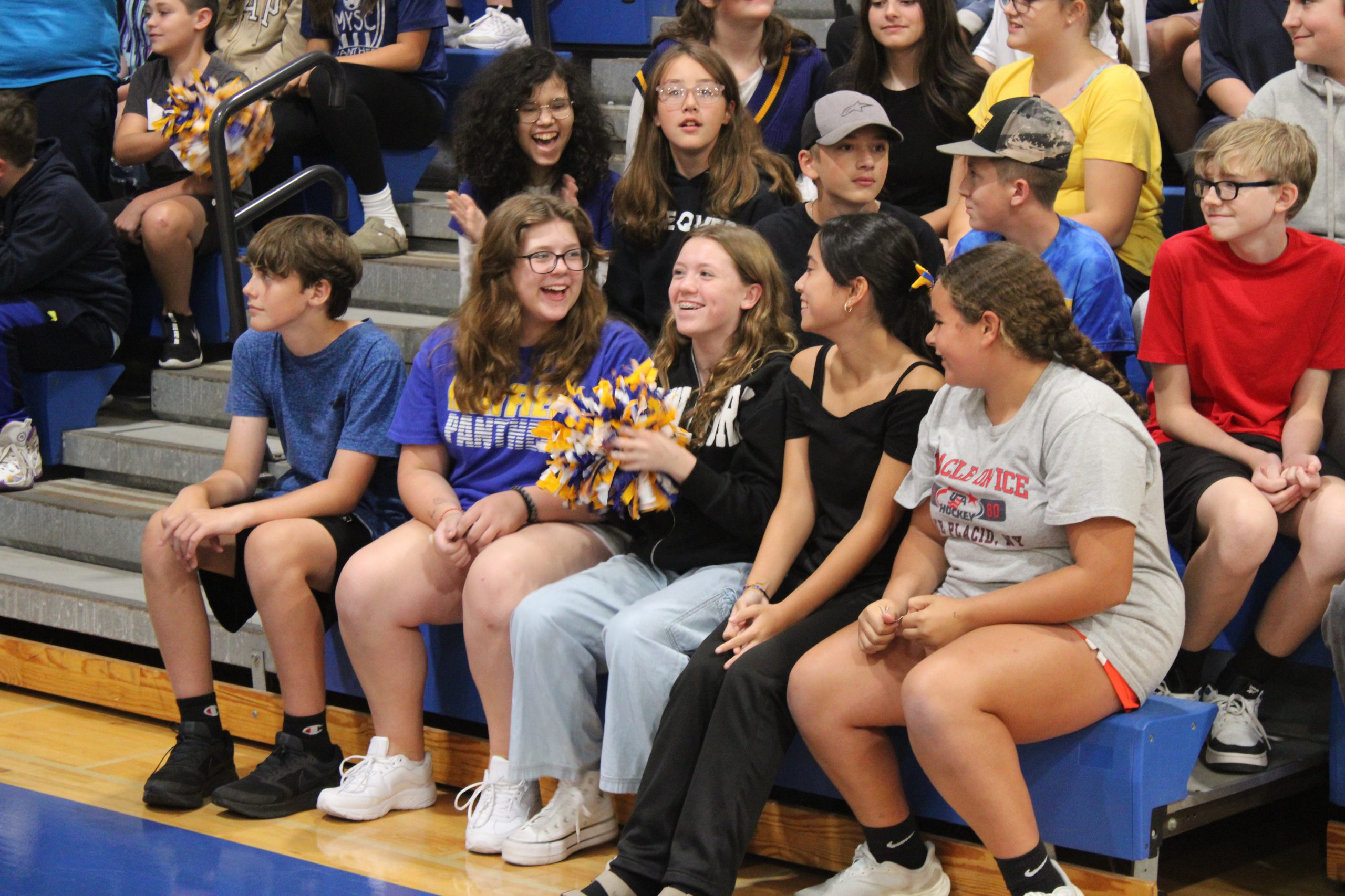 students sit on bleachers and laugh