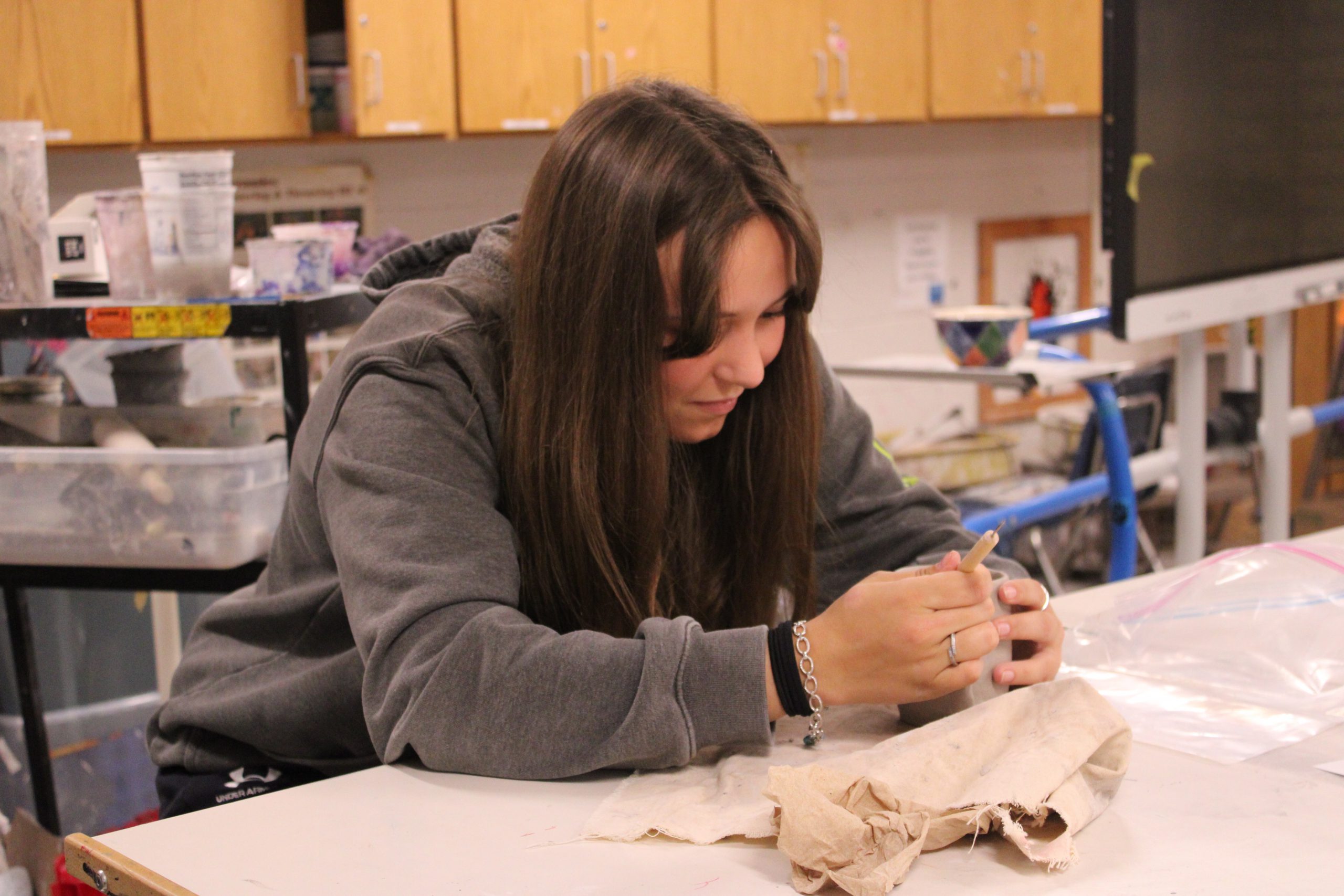 student works on clay pot