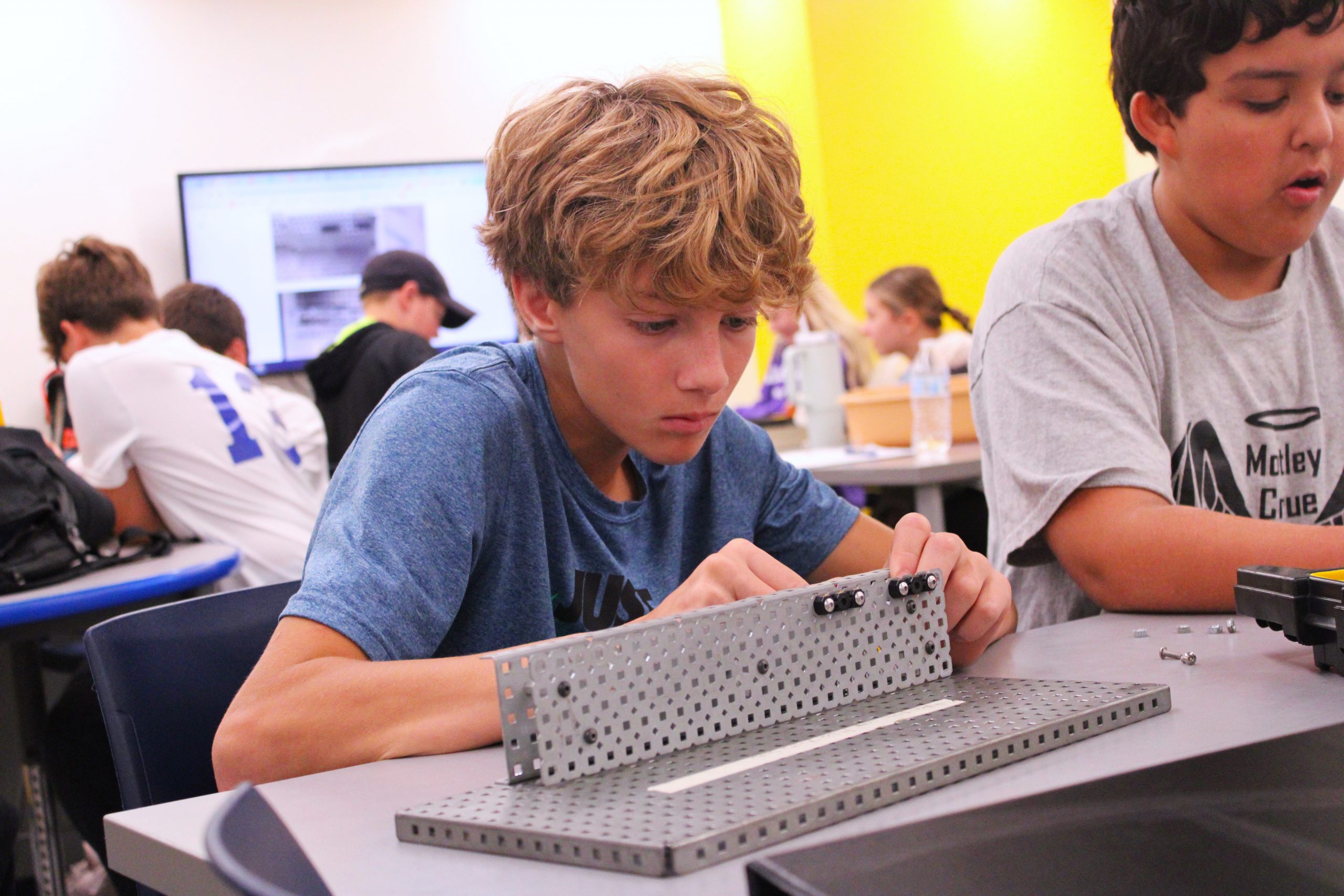 high school student works on building a mechanism